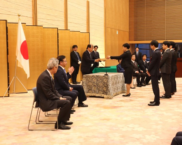 AMEDの中釜斉理事長より表彰状を授与される福田真弓臨床研究品質管理室長